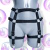 Czarna uprząż na nogi z zaczepami do pończoch. Rozmiar regulowany. Posiada jeden pasek na talii, jeden na biodrach, jeden na udzie. Harness ozdobiony kółkami. Zaprezentowany na manekinie.
