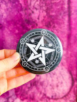 Bardzo duża przypinka typu button pin z pentagramem z symbolami alchemicznymi w kolorze czarno-białym.