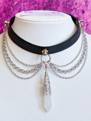 Czarny choker z kryształem górzkim w ozdobnej oprawie. Ozdobiony łańcuszkami wiszącymi po bokach.