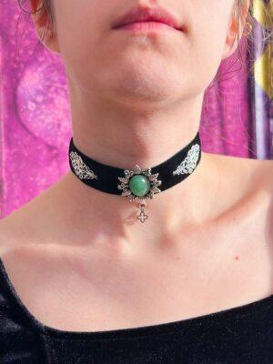 Czarna obróżka z weluru z zielonym awenturynem w ozdobnej, roślinnej oprawie. Udekorowana delikatnymi metalowymi wzorami po bokach od kamienia naturalnego. Założona na modelce.